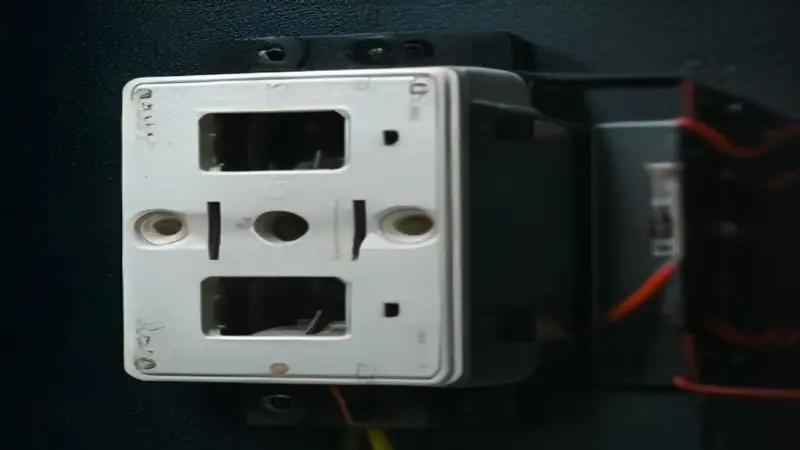 Electrical junction box with three black wires attached to a light switch.