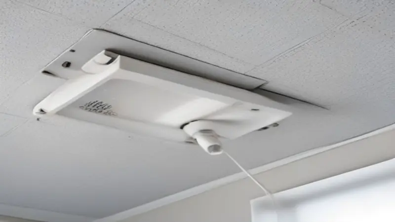A white power cord descending from a textured ceiling.
