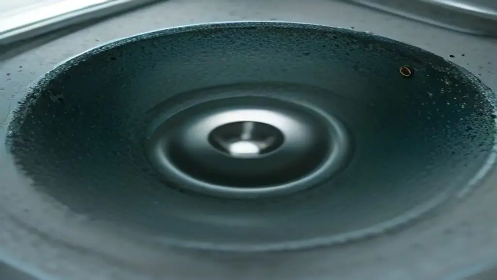 Close-up view of a metal sink drain pipe with visible corrosion and holes