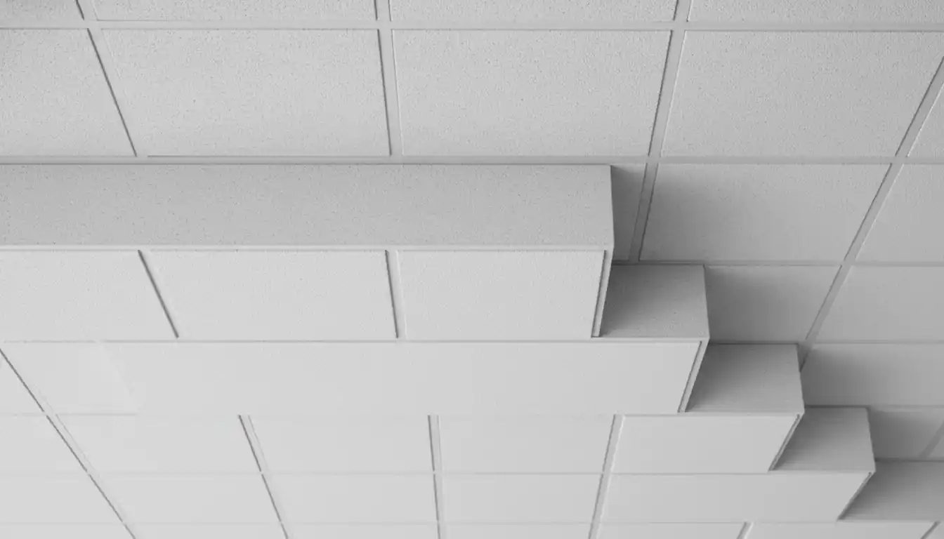 Close up detail of stepped white suspended ceiling tiles and grid system